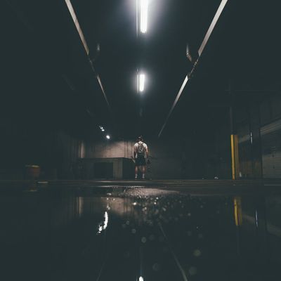 An empty, dark training space with a single mat on the floor.